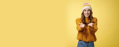 Girl suggesting take her heart smiling broadly friendly extending arms towards camera proposing help smiling delighted feeling upbeat wanna thank friend grateful appreciating effort, yellow wall photo