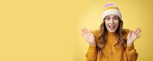 Close-up surprised excited astonished attractive female screaming happily raise hands wondered amazed winning lottery hear awesome perfect news, celebrating smiling broadly, yellow background photo