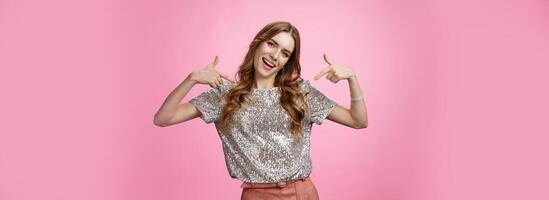 Arrogant proud attractive stylish glamour spoiled girl brag herself pointing shoulders happily pleased telling what gift received, suggesting own candidature, grinning joyful, stand pink background photo