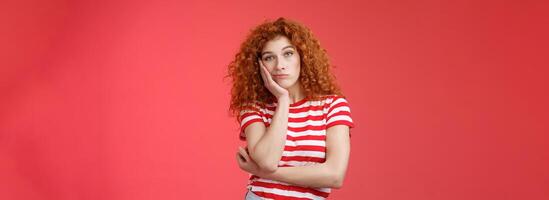 Playful redhead gorgeous girl feel sad lacking energizing party lean palm look indifferent express boredom lonely feelings attend boring meeting standing upset reluctant red background photo