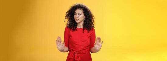 Girl unwiling got in troubles rejecting suspicious and doubtful offer pulling raised palms in no and refusal gesture turning head with grimace from aversion and disgust looking with contempt at camera photo