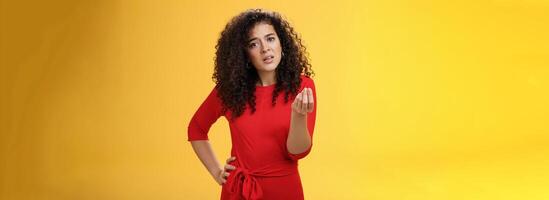 Girl being pissed off arguing ad complaining making italian what do you want gesture looking bothered waiting for explanation as standing annoyed and fed up over yellow background photo