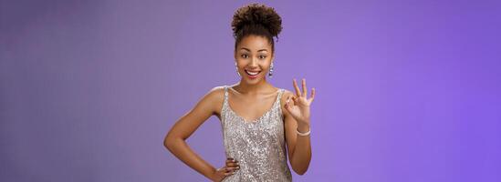 Friendly glad charming elegant african-american woman agree terms show okay ok satisfaction gesture delighted approve good idea standing blue background like plan smiling broadly photo