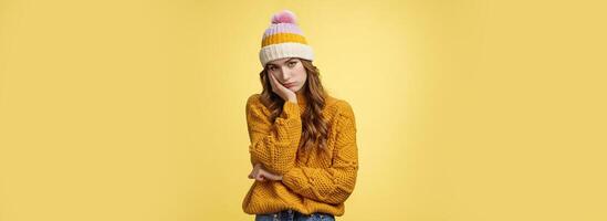 Bored annoyed fed up cute girlfriend cannot stand boring talks leaning palm indifferent look camera under forehead uninterested not paying attention, standing bothered yellow background photo