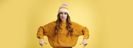 Arrogant snobbish displeased picky girl customer pointing down cringing aversion reluctance smirking unsatisfied, standing disappointed express dislike pointing down bottom advertisement photo