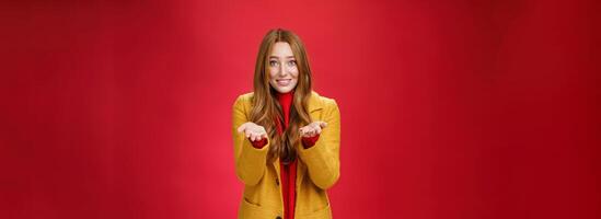 Girl with tender and caring expression smiling extanding hands forward as giving thanks or pointing at someone special feeling admiration thanking partner for support, confessing in love and sympathy photo