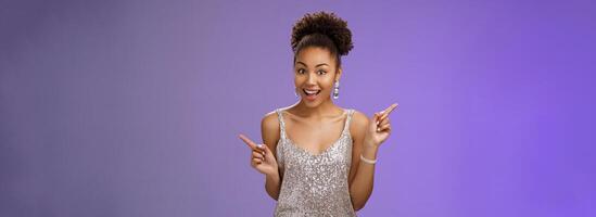 Charming outgoing african-american party girl have fun dancing pointing different sides right left show choices variants smiling broadly asking advice which way go, standing blue background photo