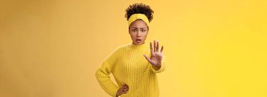 Afraid shocked insecure woman trying show voice be brave extend arm enough stop refusal gesture look frightened insecure unconfident rejecting declining offensive proposal, yellow background photo