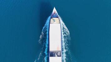 Ferry boat is sailing from the left to the right side of the frame, leaving a white trail on the surface of the water. video