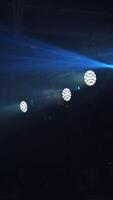 Lightning background of bright spotlights in the nightclub inside. Light show with rays from projectors at the concert. High resolution. Vertical video