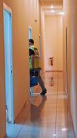 Back view of a man in protective suit and with bag going through the corridor. Male worker is carring out special bag with test tubes from the laboratory. Vertical video