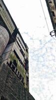 Old abandoned plant with broken windows ruined after the military actions. Demolished plant with pitted roof and some snow on the ground in winter. Bottom view Vertical video