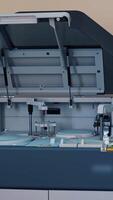 Automated machine at work and the computer screen in the laboratory room. Analysis blood at hospital laboratory. Blood samples in a robotic machine with 3D display. Vertical video
