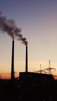 Factory tubes on the sunset background. Smoke from the pipes. Pollution concept. from the air. Vertical video