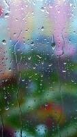 Window at rainy day on blur city background. Wet raindrops on window glass. Abstract raindrop scenery background. Vertical video
