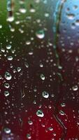 Rainy background on glass. Raindrops on window on blur background of bright dots. Drops of rain flow down the window. Drops of water drops on window pane. Vertical video