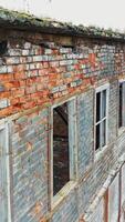 Aerial view of an old factory ruin and broken windows. Old industrial building for demolition. Vertical video