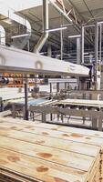Modern equipment for automating wood processing at the factory. Making parquet with the help of robotic technology and people. Vertical video