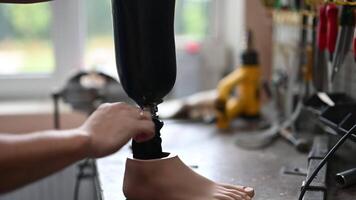 Technician adjusting a prosthetic leg in a workshop setting video