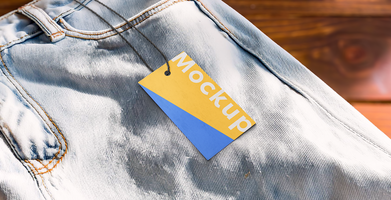 mockup of rectangular paper tag and string on jean pants with wooden background psd