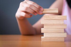 Girl's hand stacking wooden blocks. photo