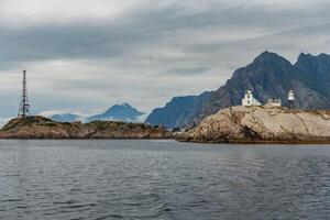Norwegian seascape, rocky coast with dramatic skies, the sun breaks through the clouds, sheer cliffs, small islands illuminated by the sun photo