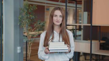 Portrait of a schoolboy of the senior classes with books in hands in a school class. video