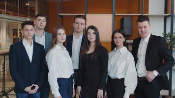 Portrait of a group of students who are in the room and smiling at the camera. video