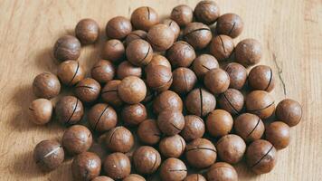 Whole macadamia nuts on the table. Many macadamia nuts lie on the table as a background. video