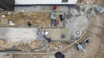Aerial view Builders paving and creating landscaping on construction sites. Craftsmen pave sidewalks and footpaths. video
