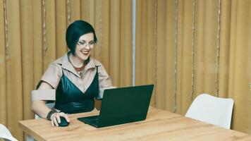 Successful woman working remotely at home. The freelancer opens a nice top and enjoys working at home. A business lady works on a laptop and demonstrates positive emotions while working at a computer. video