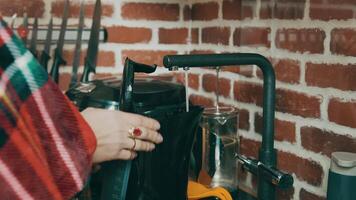 Woman who collects purified water in an electric kettle. A stream of water flows from the tap into the kettle. video
