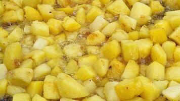 potatoes are cooked close up on a frying pan. Potato slices and hot oil. Background or texture of potatoes fried in oil. video