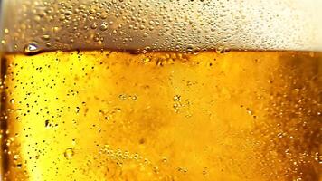 Bubbles and foam in glass with yellow liquid, drink texture video