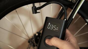4K footage of man using cordless portable air pump inflating bicycle tire video