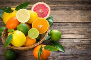 Fresh and juicy citrus fruits in the basket on the rustic table photo