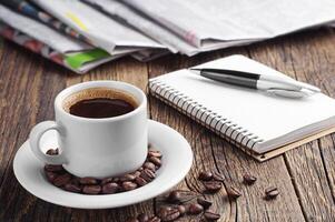 Coffee, newspaper, notepad and pen photo