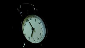 The alarm clock on a black background, in the style of time-lapse . video