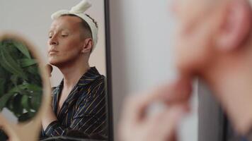 Drag queen applying makeup in front of mirror video