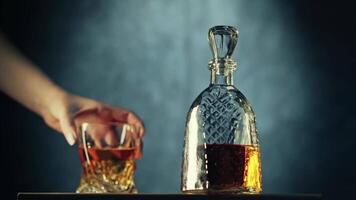 Pouring whiskey from a crystal decanter in a dimly lit room during a relaxed evening gathering video