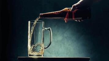 Pouring frothy beer into a glass at a bar during evening hours with dramatic lighting video