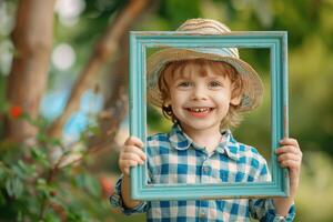 A young boy in a hat holding up a picture frame photo