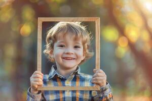 A young boy holding up a frame with his face in it photo