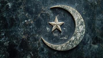 Crescent moon and star symbol on a dark marble gravestone. photo