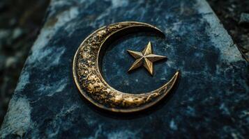 Islamic crescent moon and star design on a dark marble grave. photo