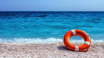 Lifebuoy Resting on a Beach with a Blue Water Backdrop photo