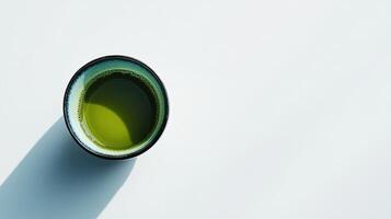down perspective of matcha green tea in a cup on a white table photo