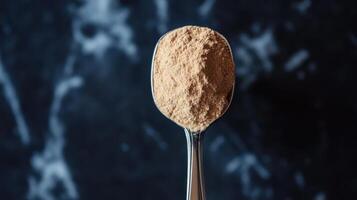 Spoon with a serving of BCAA beta-glucan anabolic whey protein powder. photo