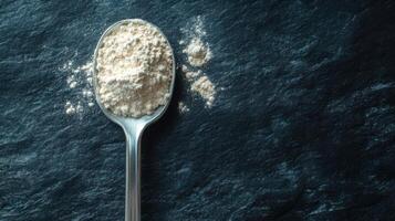 Spoon with a serving of BCAA beta-glucan anabolic whey protein powder. photo