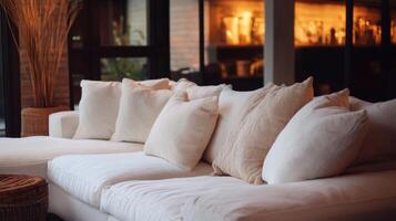 A white couch with pillows and a coffee table photo